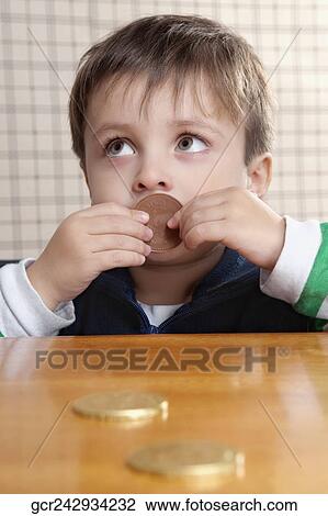 Stock Image - Close-up of a boy eating cookies. Fotosearch
