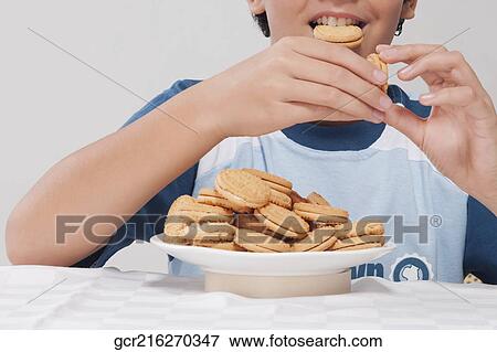 Close-up of a boy eating cookies View Large Photo Image Stock Photo - Close-up of a boy eating cookies. Fotosearch