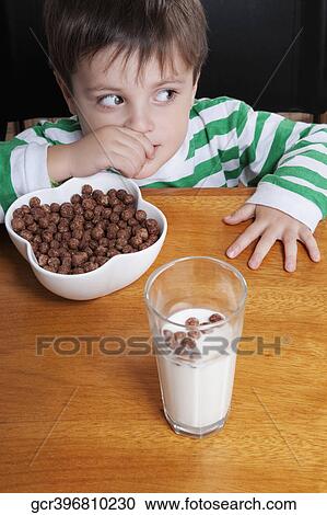 Close-up of a boy eating dry cereal View Large Photo Image Stock Image - Close-up of a boy eating dry cereal. Fotosearch