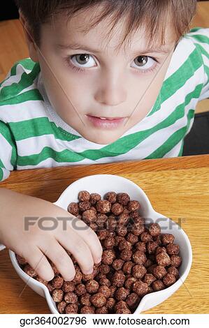 Close-up of a boy eating dry cereal View Large Photo Image Stock Photograph - Close-up of a boy eating dry cereal. Fotosearch