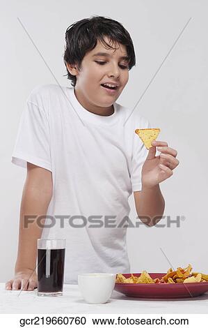 Close-up of a boy eating nachos View Large Photo Image Stock Image - Close-up of a boy eating nachos. Fotosearch