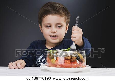 Close-up of a boy eating salad View Large Photo Image Stock Photograph - Close-up of a boy eating salad. Fotosearch