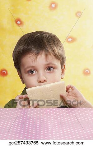 Close-up of a boy holding a bar of white chocolate View Large Photo Image Stock Photography - Close-up of a boy holding a bar of white chocolate. Fotosearch