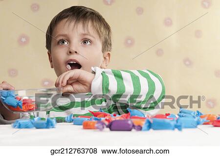 Close-up of a boy holding a bowl of candies View Large Photo Image Stock Photo - Close-up of a boy holding a bowl of candies. Fotosearch