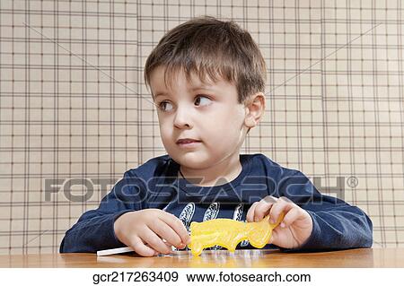 Close-up of a boy holding a candy View Large Photo Image Stock Photo - Close-up of a boy holding a candy. Fotosearch