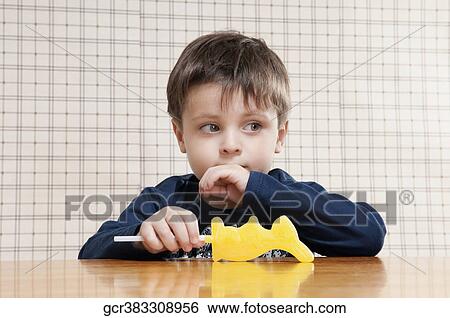 Stock Photograph - Close-up of a boy holding a candy. Fotosearch
