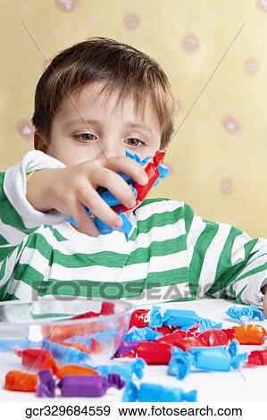 Close-up of a boy holding a handful of candies View Large Photo Image Stock Photo - Close-up of a boy holding a handful of candies. Fotosearch