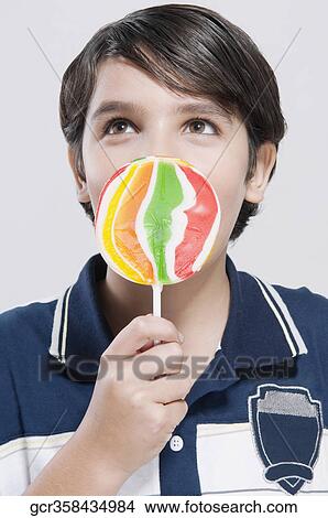 Close-up of a boy holding a lollipop View Large Photo Image Picture - Close-up of a boy holding a lollipop. Fotosearch