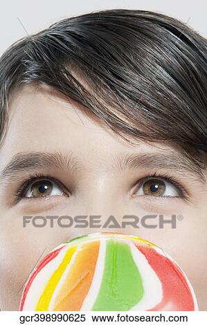 Close-up of a boy holding a lollipop View Large Photo Image Stock Photography - Close-up of a boy holding a lollipop. Fotosearch