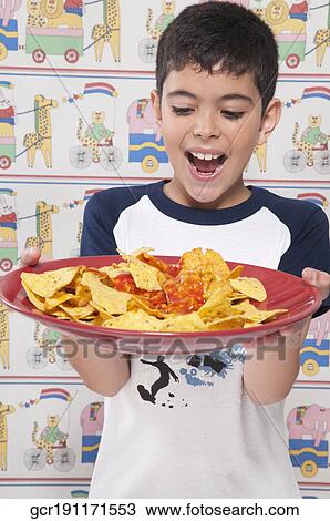 Close-up of a boy holding a platter of nachos View Large Photo Image Stock Image - Close-up of a boy holding a platter of nachos. Fotosearch