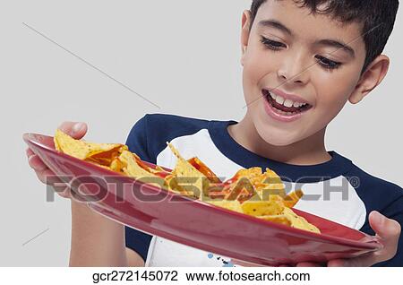 Close-up of a boy holding a platter of nachos View Large Photo Image Stock Image - Close-up of a boy holding a platter of nachos. Fotosearch