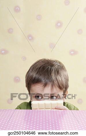 Close-up of a boy holding a white chocolate bar View Large Photo Image Stock Photograph - Close-up of a boy holding a white chocolate bar. Fotosearch
