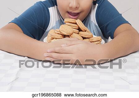 Stock Photo - Close-up of a boy hugging a plate of cookies. Fotosearch