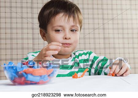 Close-up of a boy looking at a bowl of candies View Large Photo Image Stock Photo - Close-up of a boy looking at a bowl of candies. Fotosearch