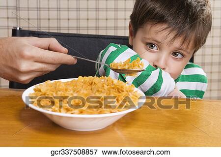 Stock Photo - Close-up of a boy refusing corn flakes. Fotosearch