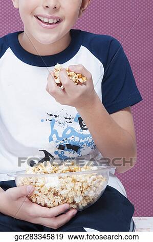 Close-up of a boy with a handful of popcorn View Large Photo Image Stock Photo - Close-up of a boy with a handful of popcorn. Fotosearch