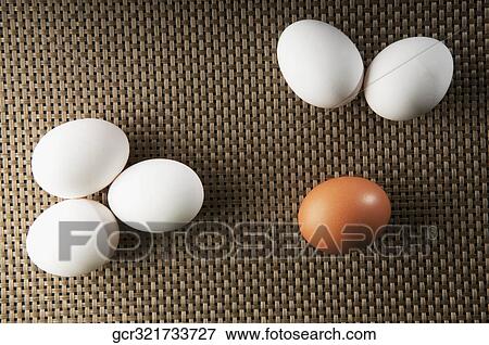 Stock Photo - Close-up of a brown egg with white eggs. Fotosearch