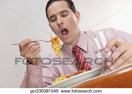 Close-up of a businessman eating pasta View Large Photo Image Stock Photo - Close-up of a businessman eating pasta. Fotosearch