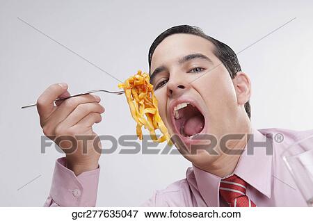 Close-up of a businessman eating pasta View Large Photo Image Stock Photo - Close-up of a businessman eating pasta. Fotosearch