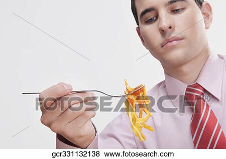 Close-up of a businessman eating pasta View Large Photo Image Stock Photo - Close-up of a businessman eating pasta. Fotosearch