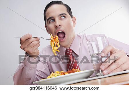 Close-up of a businessman eating pasta View Large Photo Image Stock Photograph - Close-up of a businessman eating pasta. Fotosearch