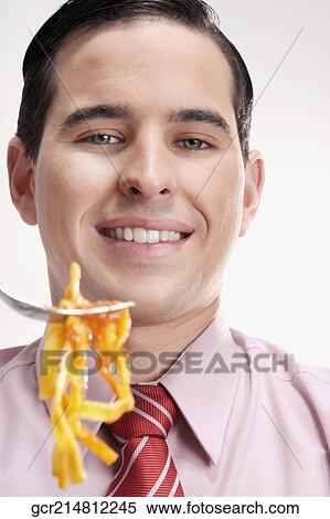 Close-up of a businessman eating pasta View Large Photo Image Stock Photography - Close-up of a businessman eating pasta. Fotosearch
