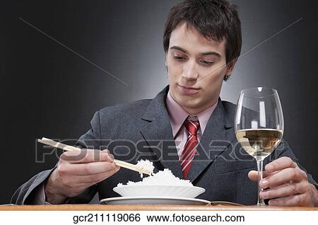 Close-up of a businessman eating rice with chopsticks View Large Photo Image Stock Photograph - Close-up of a businessman eating rice with chopsticks. Fotosearch