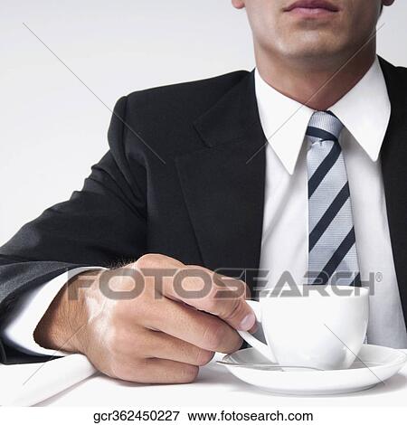 Close-up of a businessman holding a cup of coffee View Large Photo Image Stock Photo - Close-up of a businessman holding a cup of coffee. Fotosearch