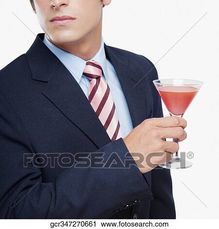 Stock Image - Close-up of a businessman holding a cocktail. Fotosearch