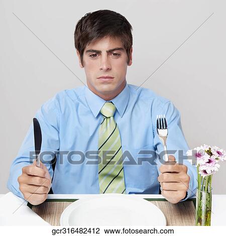 Stock Image - Close-up of a businessman waiting for dinner. Fotosearch
