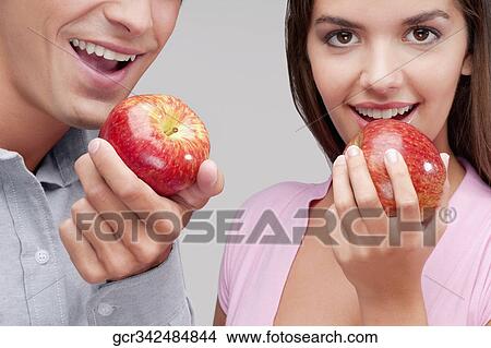 Close-up of a couple eating apples View Large Photo Image Picture - Close-up of a couple eating apples. Fotosearch
