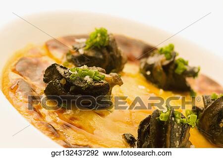 Stock Image - Close-up of a dish garnished with truffles. Fotosearch