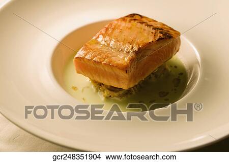 Picture - Close-up of a fish steak on a bed of pasta. Fotosearch