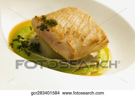 Close-up of a fish steak on a bed of sauce View Large Photo Image Picture - Close-up of a fish steak on a bed of sauce. Fotosearch