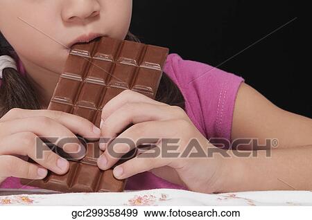 Close-up of a girl eating a bar of chocolate View Large Photo Image Stock Photo - Close-up of a girl eating a bar of chocolate. Fotosearch