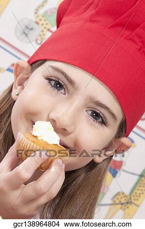 Close-up of a girl eating a cupcake View Large Photo Image Picture - Close-up of a girl eating a cupcake. Fotosearch