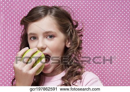 Close-up of a girl eating an apple View Large Photo Image Stock Image - Close-up of a girl eating an apple. Fotosearch