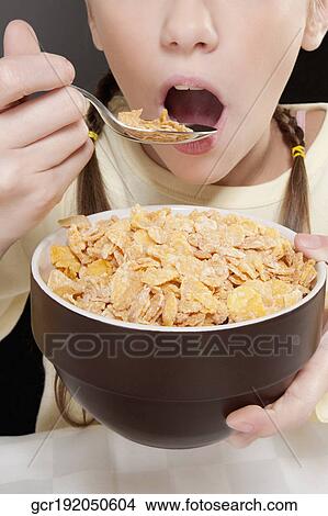 Close-up of a girl eating corn flakes View Large Photo Image Picture - Close-up of a girl eating corn flakes. Fotosearch