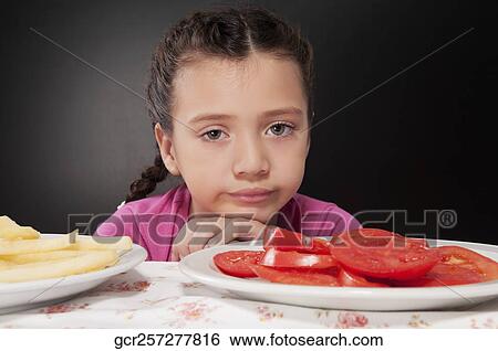Close-up of a girl frowning with a plate of tomato slices View Large Photo Image Stock Photograph - Close-up of a girl frowning with a plate of tomato slices. Fotosearch