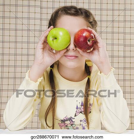 Close-up of a girl holding apples over her eyes View Large Photo Image Stock Image - Close-up of a girl holding apples over her eyes. Fotosearch