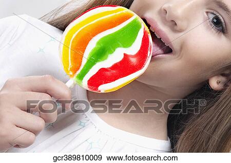Close-up of a girl licking a lollipop View Large Photo Image Stock Photo - Close-up of a girl licking a lollipop. Fotosearch
