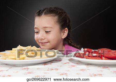 Close-up of a girl looking at French fries View Large Photo Image Stock Image - Close-up of a girl looking at French fries. Fotosearch