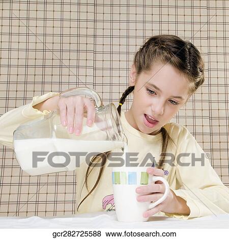 Close-up of a girl pouring milk in a cup View Large Photo Image Stock Photo - Close-up of a girl pouring milk in a cup. Fotosearch