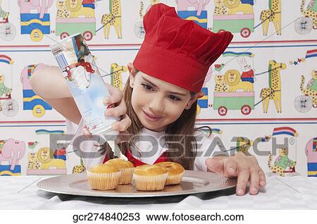Close-up of a girl putting whipped cream on cupcakes View Large Photo Image Stock Image - Close-up of a girl putting whipped cream on cupcakes. Fotosearch
