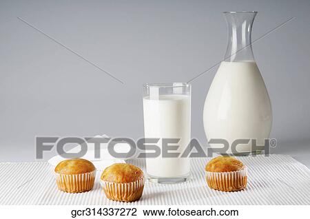 Close-up of a glass of milk with cupcakes View Large Photo Image Stock Image - Close-up of a glass of milk with cupcakes. Fotosearch