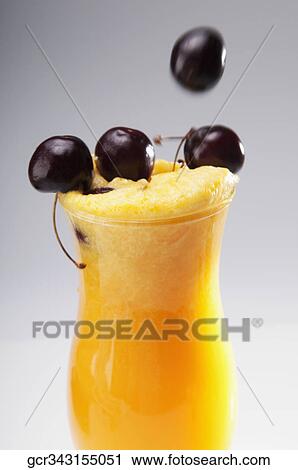 Close-up of a glass of orange juice with black cherries View Large Photo Image Stock Image - Close-up of a glass of orange juice with black cherries. Fotosearch