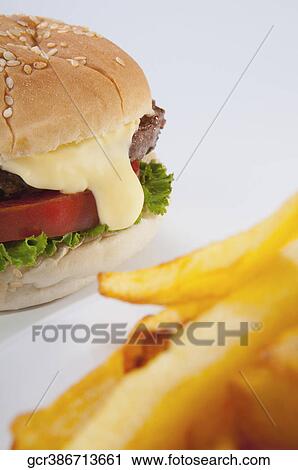 Stock Image - Close-up of a hamburger with French fries. Fotosearch
