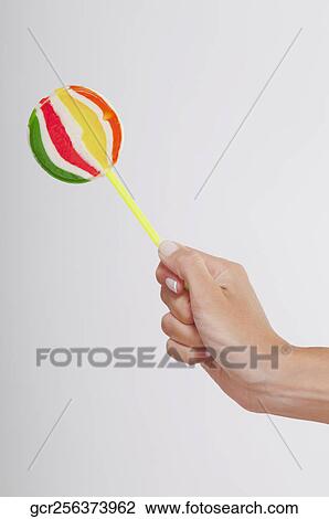 Close-up of a human's hand holding a lollipop View Large Photo Image Stock Image - Close-up of a human's hand holding a lollipop. Fotosearch