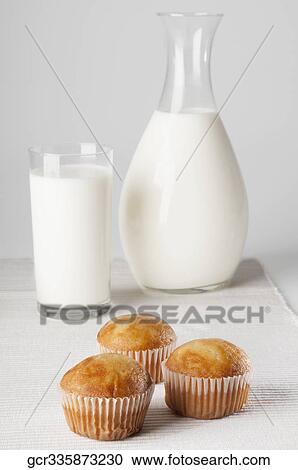 Close-up of a jug and a glass of milk with cupcakes View Large Photo Image Stock Image - Close-up of a jug and a glass of milk with cupcakes. Fotosearch