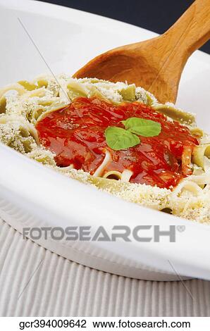 Close-up of a ladle in fettuccine topped with tomato sauce View Large Photo Image Stock Image - Close-up of a ladle in fettuccine topped with tomato sauce. Fotosearch